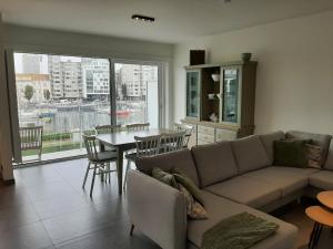 a living room with a couch and a table at Driemaster, Stijlvol appartement met uitzicht op jachthaven en privé parking, centrum Oostende in Ostend