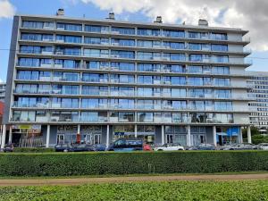 a large building with cars parked in front of it at Driemaster, Stijlvol appartement met uitzicht op jachthaven en privé parking, centrum Oostende in Ostend