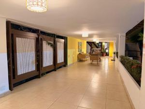 a hallway with yellow walls and a tile floor at Girassol Praia Hotel in Porto Seguro