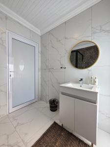 White Cottage Boutique Guesthouse في سواكوبموند: حمام أبيض مع حوض ومرآة