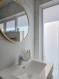 White Cottage Boutique Guesthouse في سواكوبموند: حمام مع حوض أبيض ومرآة +13 صورة