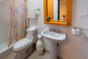 un bagno con lavandino, WC e specchio di Suite apartment 201 Playa Santa Marianita Manta by BRISAMAR a Manta