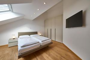 巴德米滕多夫Ferienwohnung Grimmingblick的一间卧室，里面有一张床和一台平板电视