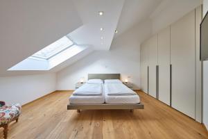 巴德米滕多夫Ferienwohnung Grimmingblick的白色卧室设有床和天窗