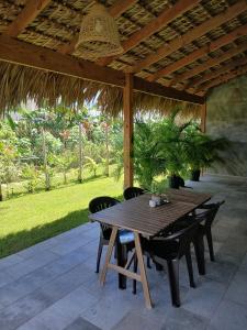 a wooden table and chairs under a wooden pergola at APARTAMENTO EXCLUSIVO Villa Privada Flamboyan in Bayahibe