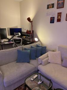ein Wohnzimmer mit einer Couch und einem Schreibtisch mit einem Computer in der Unterkunft Friendly apartment with friendly pet in Riad
