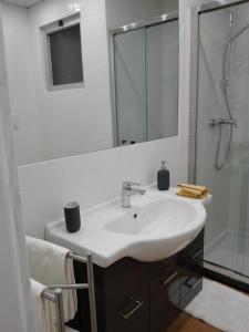 y baño blanco con lavabo y ducha. en Sul Tetto di Gallipoli, en Gallipoli