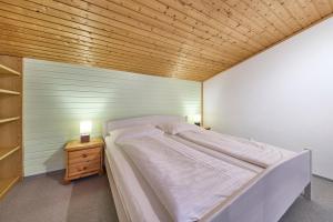 Una cama grande en una habitación con techo de madera. en Ferienwohnung Brigitte, en Bad Mitterndorf