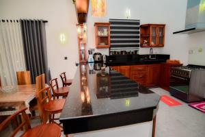 eine Küche mit einer schwarzen Arbeitsplatte und einem Tisch in der Unterkunft Iman House in Nikawatawana