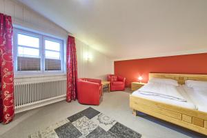 Un dormitorio con una cama y una pared roja. en Ferienwohnung Brigitte, en Bad Mitterndorf