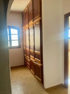 uno spogliatoio con armadi in legno e una finestra di Magnifique villa alliant tradition et modernité en plein oliveraie 