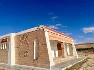 un piccolo edificio di mattoni in mezzo a un campo di Magnifique villa alliant tradition et modernité en plein oliveraie 