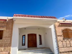 una piccola casa bianca con una porta in legno di Magnifique villa alliant tradition et modernité en plein oliveraie 