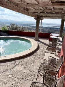 a swimming pool with chairs and a table on a patio at Casa La Vista in San Miguel de Allende