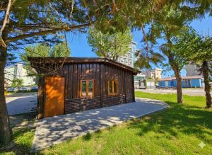 eine kleine Hütte in einem Park mit Bäumen in der Unterkunft Bungalow e Mobilhome - Camper Park 2 in Rimini
