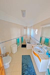een badkamer met een wastafel, een toilet en een bad bij Ericeira Sunset Apartment in Ericeira