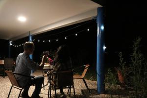 um homem e uma mulher sentados numa mesa debaixo de uma tenda em Soothing 2-bedroom country house in Huayllabamba em Huayllabamba