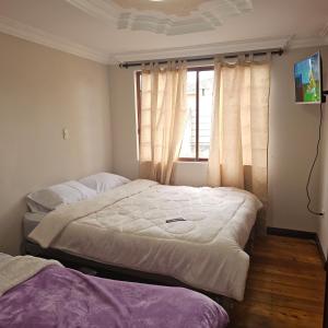 due letti in una stanza con finestra di Casa grande cerca de todo a Cuenca