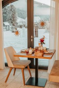 uma mesa com um prato de comida na frente de uma janela em Löckerwirt em Sankt Margarethen im Lungau