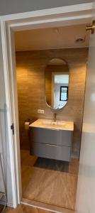 um banheiro com uma pia e um espelho em Zeeuwse Ontspanning em Kapelle