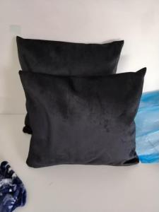 two black pillows sitting on a bed at Studio San in Arandjelovac