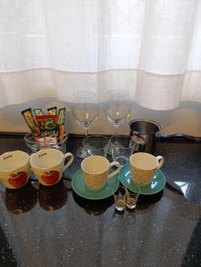 a group of cups and glasses on a table at Studio San in Arandjelovac