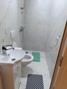 a bathroom with a sink and a toilet and a shower at Studio San in Arandjelovac