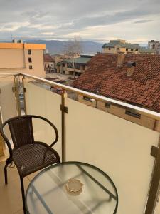 einen Glastisch und einen Stuhl auf dem Balkon in der Unterkunft City Comfort Apartment in Vranje + 1 Foto