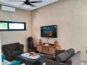 a living room with two couches and a flat screen tv at Villa Puri Mesari Amed in Amed