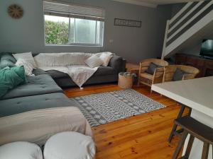 a living room with a couch and a table at Sunbird 2 in Cape St Francis +9 photos