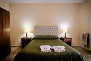 een slaapkamer met een bed met twee handdoeken erop bij Carlos Paz Departamentos in Villa Carlos Paz +37 foto's