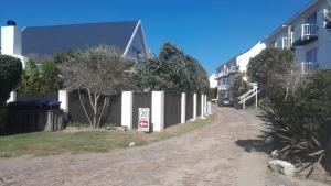 a street with a white fence and a no parking sign at Sunbird 2 in Cape St Francis