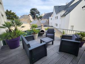 ein Balkon mit Stühlen und einem Tisch und einem Grill in der Unterkunft Maison Vue Mer in Pornichet