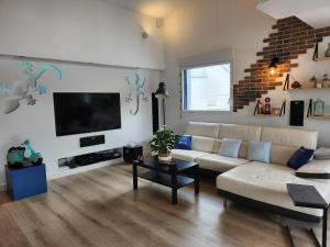 ein Wohnzimmer mit Sofa und Flachbildfernseher in der Unterkunft Maison Vue Mer in Pornichet