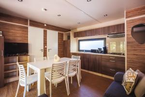 Una cocina y un comedor con una mesa y sillas blancas. en Nova Lodges, en Grimaud