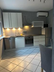 普丰斯塔特Modern 2-room apartment with large kitchen的带白色橱柜和水槽的厨房