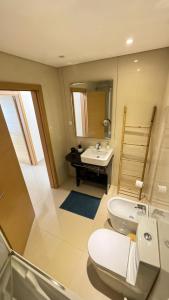 une salle de bains avec toilettes et lavabo dans l'établissement Laguna mar beach house, à Monte Gordo