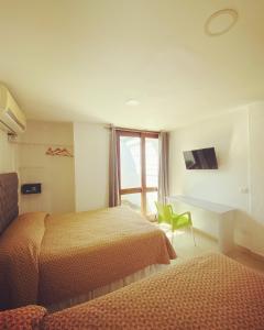 a bedroom with two beds and a chair and a window at Casa San Juan 560 in Managua