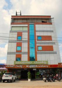 Un edificio con dos hombres de pie encima. en Mayuri Residency Attibele, en Bangalore