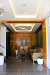 Un vestíbulo con un sofá y plantas en un edificio. en Mayuri Residency Attibele, en Bangalore