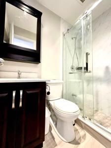 a bathroom with a toilet and a glass shower at Cozy Queen room with Shared Bath near Seneca Finch 404 in Toronto
