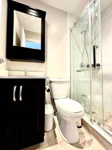 a bathroom with a toilet and a shower and a television at Cozy Queen room with Shared Bath near Seneca Finch 404 in Toronto