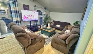 Waterfront 2-BR Cottage Retreat in Manitoulin Island في Kagawong: غرفة معيشة مع أرائك وتلفزيون بشاشة مسطحة