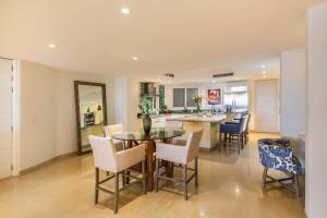 a kitchen and dining room with a table and chairs at Luxury Oceanfront Condo Infinity Pool in Punta Mita