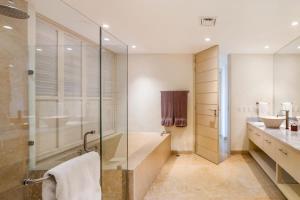 a bathroom with a glass shower and a sink at Luxury Oceanfront Condo Infinity Pool in Punta Mita