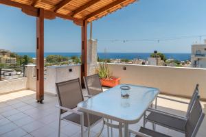 a patio with a table and chairs on a balcony at Mirtos4seasons Harmony in Myrtos