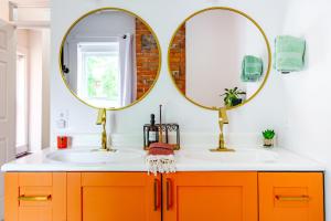 a bathroom with two sinks and two mirrors at Jungle House Columbus Short North Downtown Free Parking - Walk to Convention Center & Nationwide Arena - 4BR Luxury Home - Sleeps 20 - Over 5,800 Five Star Stays in Columbus +130 photos