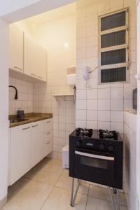 a small kitchen with a black stove in it at 4 minutos da Praia de Copacabana - NSC803 in Rio de Janeiro