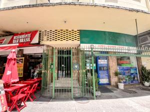 a cage in front of a store with red tables and chairs at 4 minutos da Praia de Copacabana - NSC803 in Rio de Janeiro