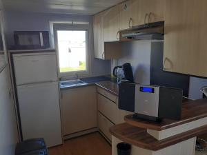 eine kleine Küche mit einem Schreibtisch und einem Computer darauf in der Unterkunft NORDSEE GLAMPING MobilheimChalet 2154 in Bredene